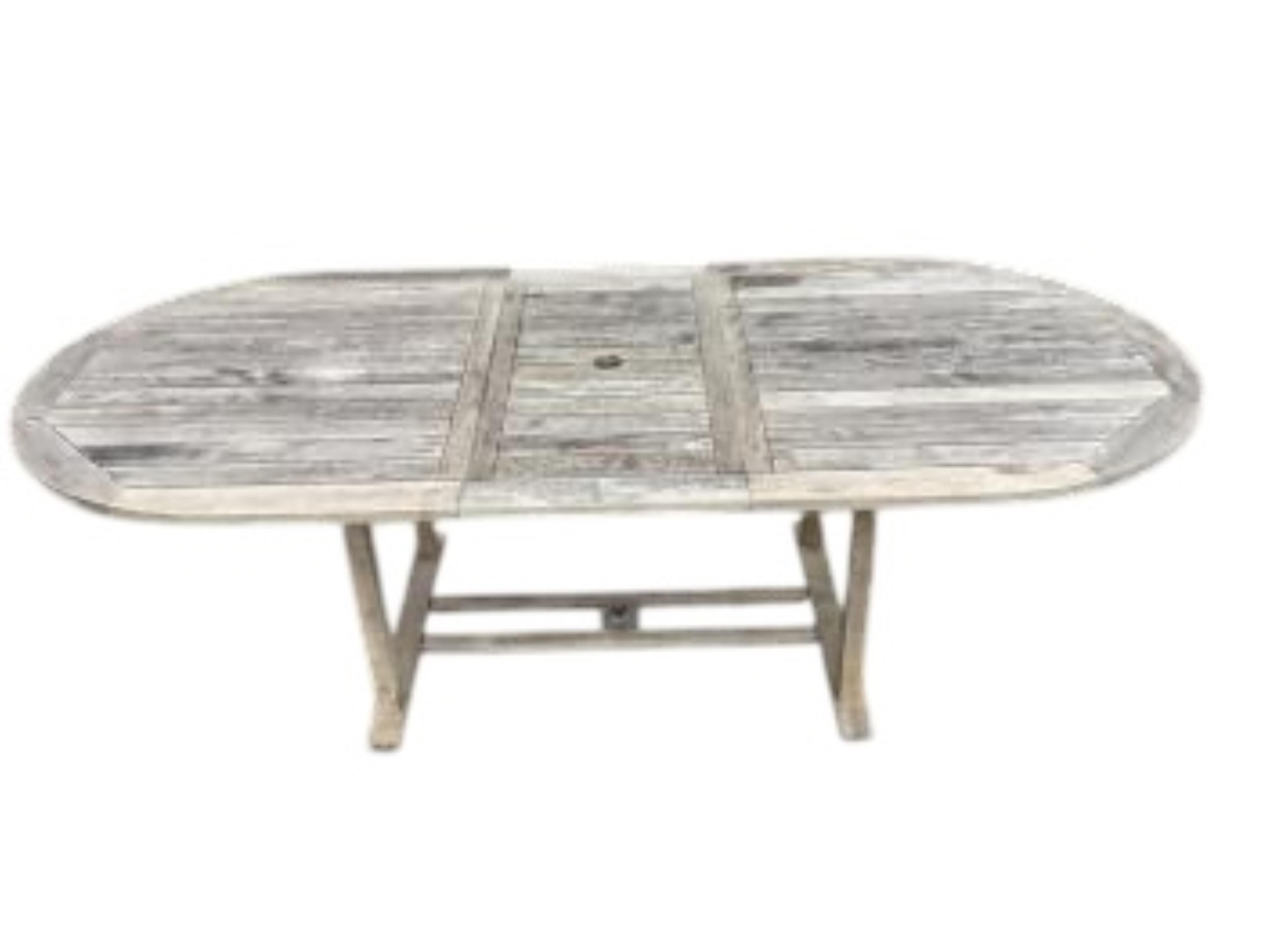 A weathered teak oval extending garden table, width 239cm extended, depth 109cm, height 73cm together with six Neptune weathered teak folding reclining garden armchairs with five Neptune cushions